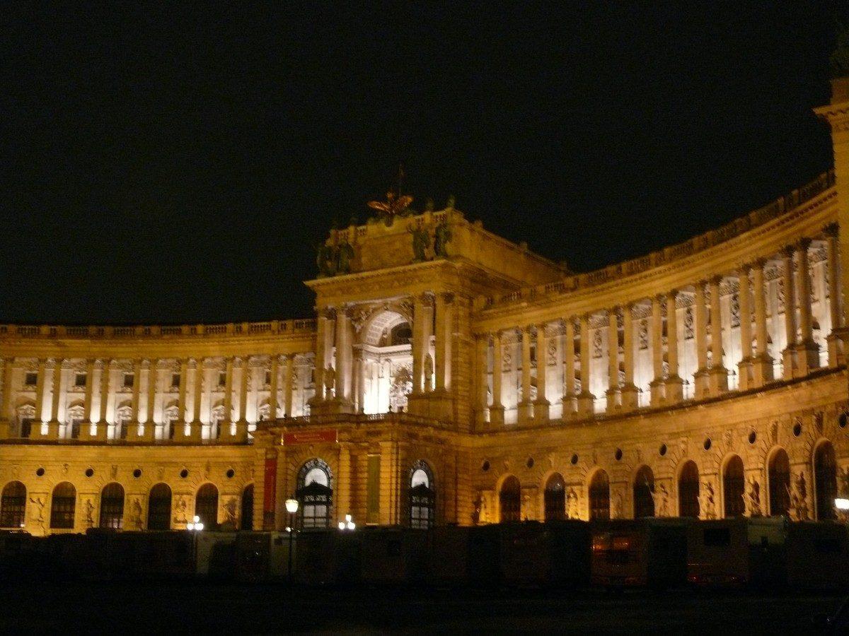 Die Wiener Hofburg bei Nacht, in Orange angestrahlt.
